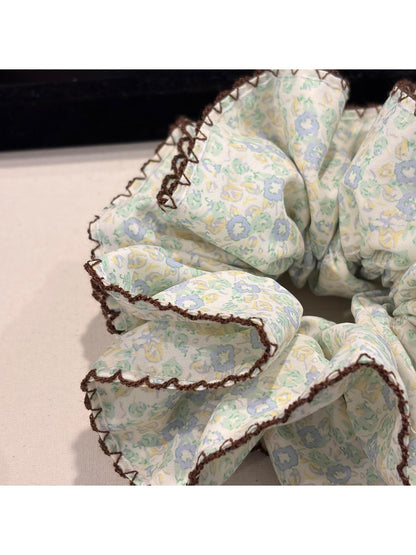 Gifty scrunchie styled on a wrist with vintage floral print