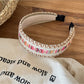 Gifty vintage wide edge woven headband styled on a mannequin head with a neutral background