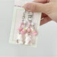 Close-up of a pink flocked bunny shaped keychain with a metal keyring