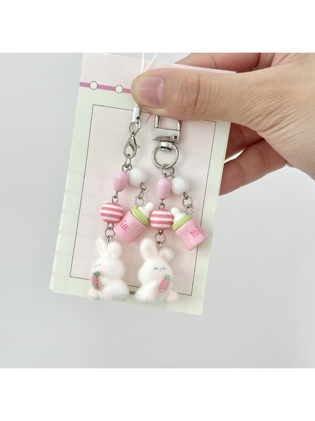 Close-up of a pink flocked bunny shaped keychain with a metal keyring