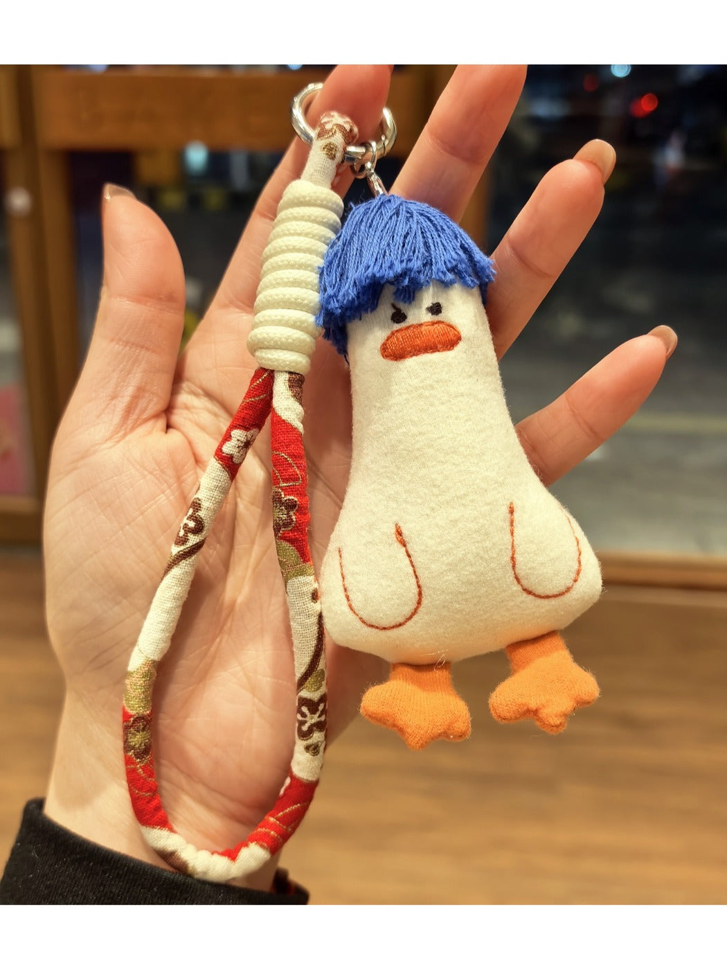 Blue duck keychain held in hand to show size and texture
