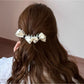Side view of Beau polka dot bow banana clip with curved shape