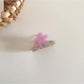 Beau flower shaped hair clip clipped onto a section of blonde hair