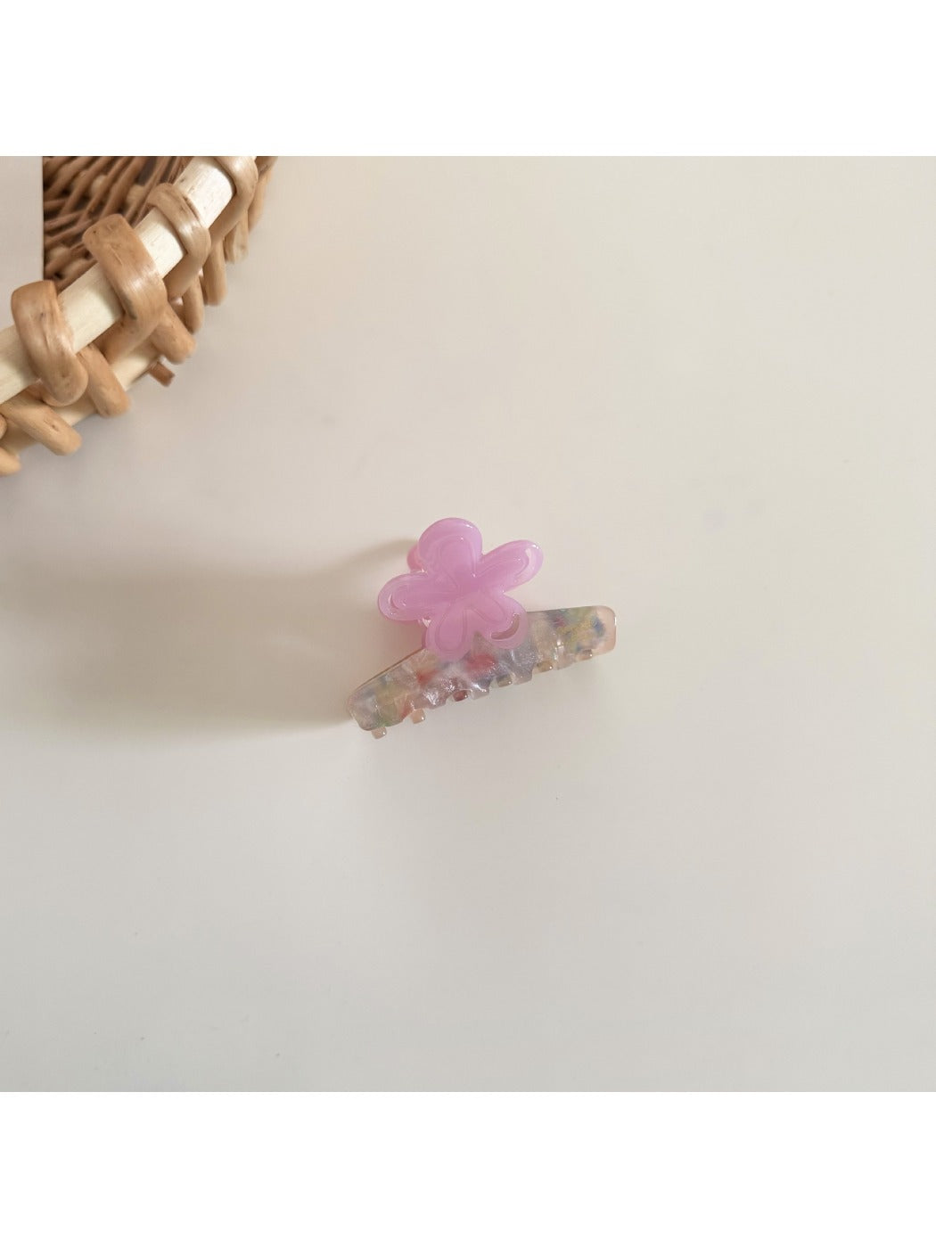 Beau flower shaped hair clip clipped onto a section of blonde hair