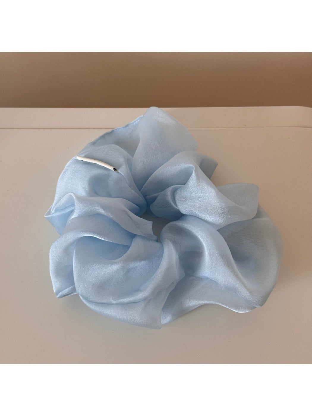 Scrunchie laid flat showing full circular shape and floral pattern