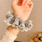 Close-up of gray ruffle scrunchie showing fabric texture and stitching