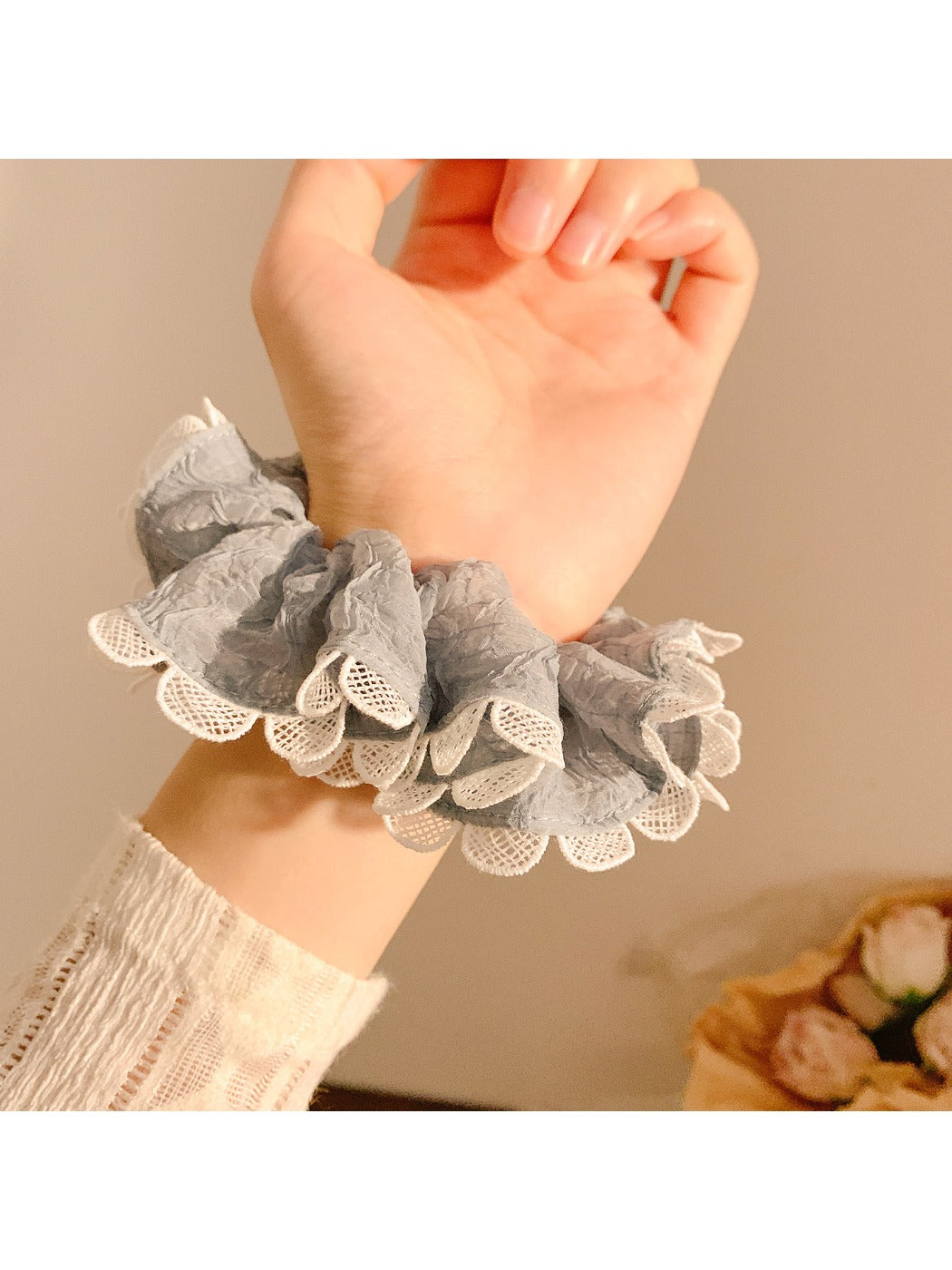 Close-up of gray ruffle scrunchie showing fabric texture and stitching