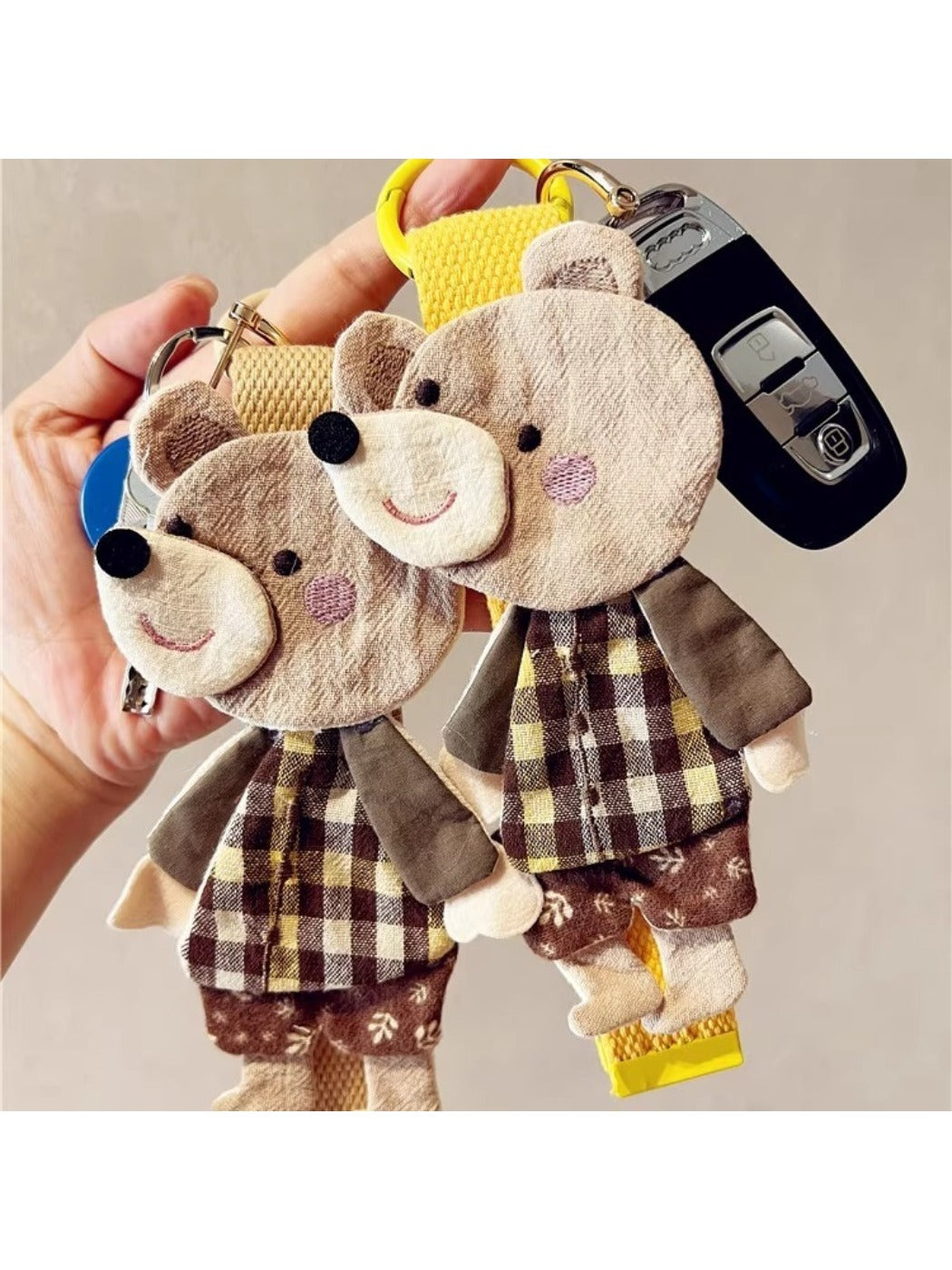 Close-up of the bear keychain's patchwork fabric showing detailed stitching and texture