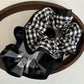 Black and white check scrunchie displayed on a wooden surface