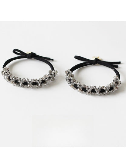 Gifty beaded hair tie worn on a wrist showing its simple and elegant design