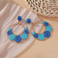 Sweet Raffia Circle Stud Earrings displayed on a wooden surface
