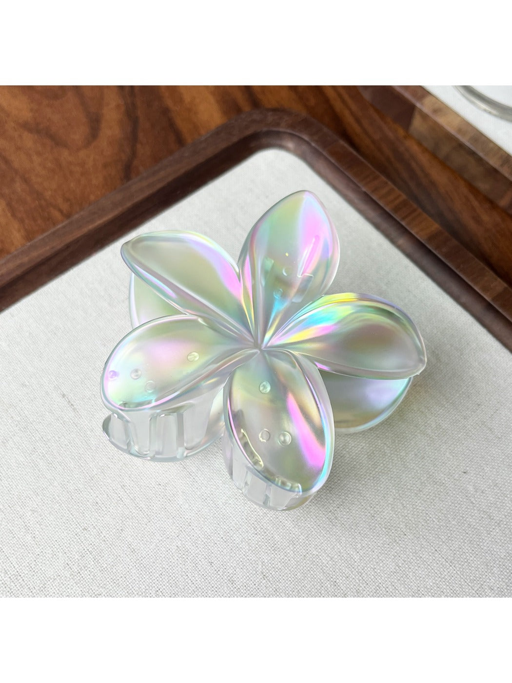 Beau flower shaped claw clip clipped onto hair showing usage example