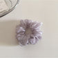 Scrunchie displayed on a wooden surface highlighting fabric details