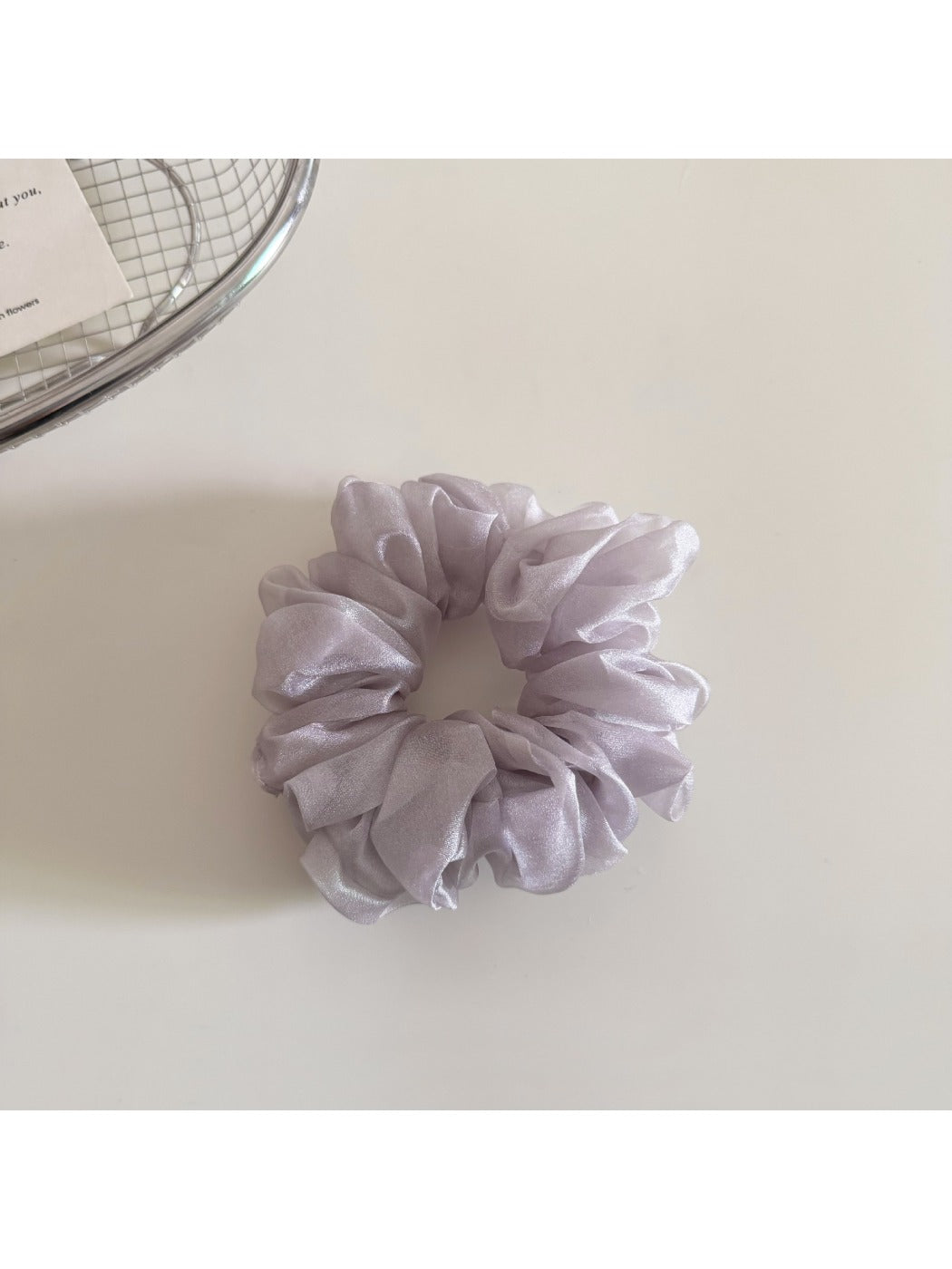 Scrunchie displayed on a wooden surface highlighting fabric details