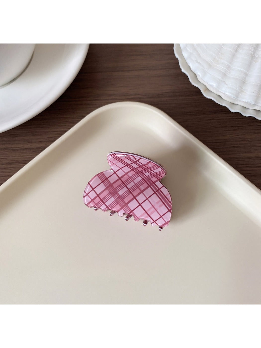 Beau hair claw clip with pink plaid pattern next to matching accessories