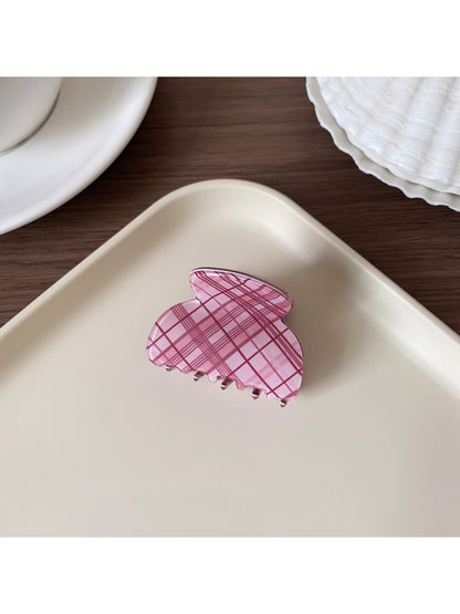 Beau hair claw clip with pink plaid pattern next to matching accessories