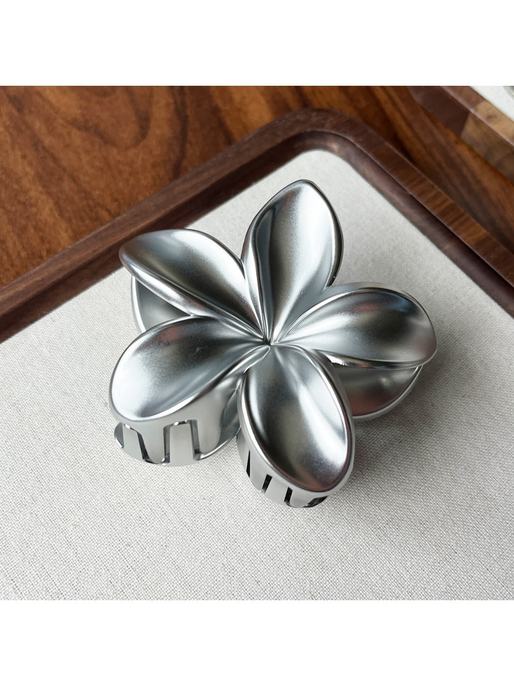 Beau flower shaped claw clip shown alongside matching accessories