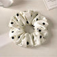 Side view of Gifty minimalist satin polka dot scrunchie showing fabric texture