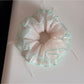 Gifty Ribbon Knot Tulle Scrunchie styled in a ponytail on a model with dark hair