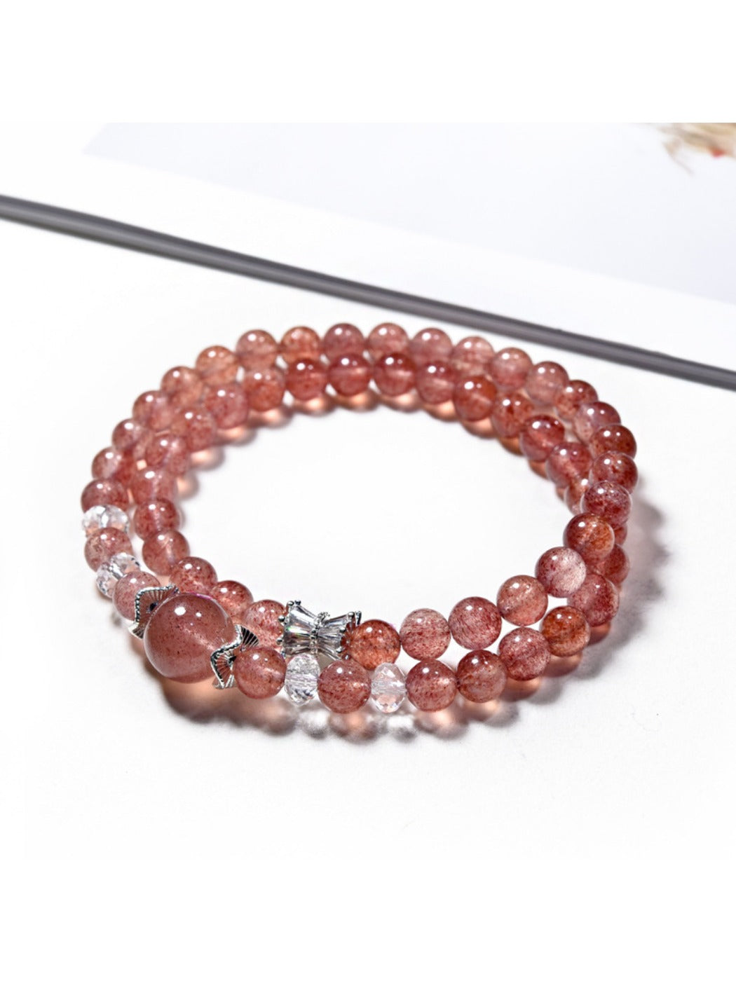 Lovra multi-wrap bracelet featuring polished strawberry quartz beads and silver accents
