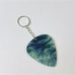 Teardrop charm keychain attached to a set of keys with a blurred background