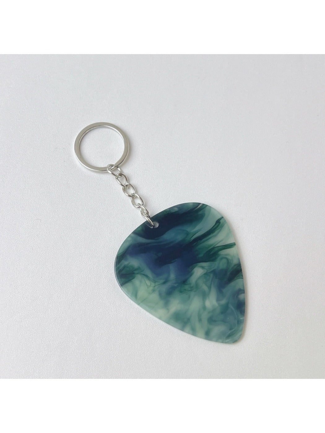 Teardrop charm keychain attached to a set of keys with a blurred background