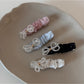 Close-up of Beau sparkling bow hair clip with clear rhinestones on a white background