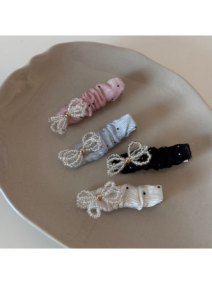Close-up of Beau sparkling bow hair clip with clear rhinestones on a white background
