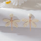 Raffia dragonfly earrings styled with casual outfit on model