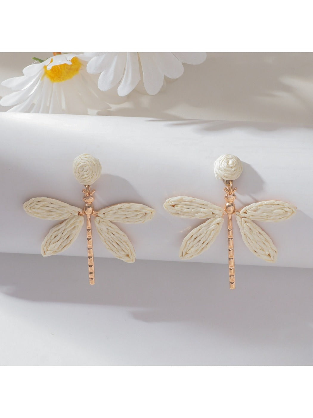 Raffia dragonfly earrings styled with casual outfit on model