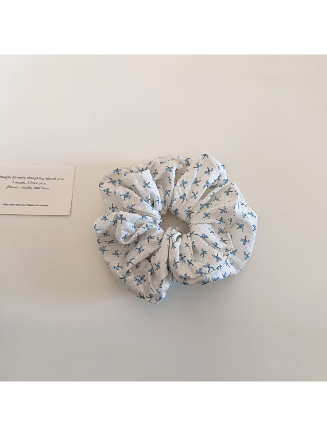 Gifty ditsy floral scrunchie stretched to show elastic band inside soft floral fabric