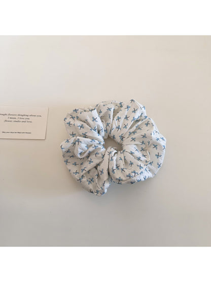 Gifty ditsy floral scrunchie stretched to show elastic band inside soft floral fabric