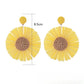 Pair of cute raffia sunflower earrings displayed on a white background