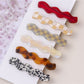 Side angle of Beau wavy hair clip showing curved design and clasp