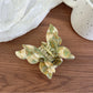 Pastel pink butterfly claw clip displayed with soft lighting