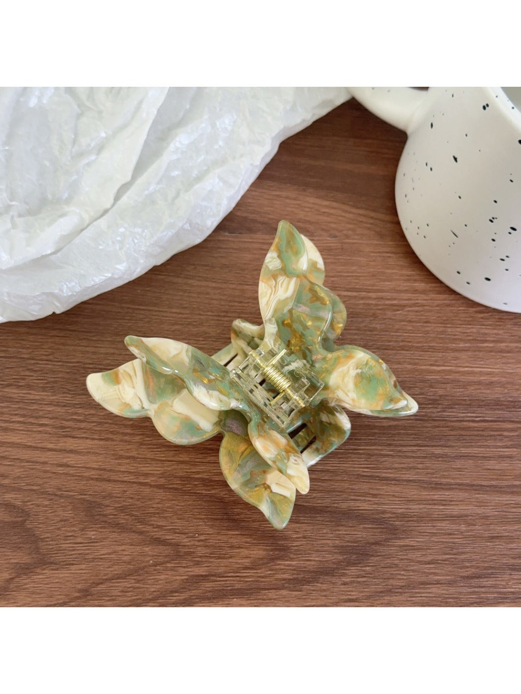 Pastel pink butterfly claw clip displayed with soft lighting