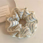 Gifty striped scrunchie styled on a ponytail showing its stretch and fabric texture