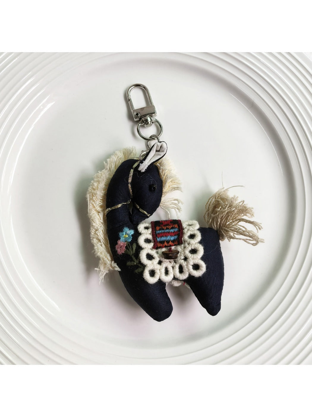 Fabric pony keychain with soft pastel colors and metal keyring on white background