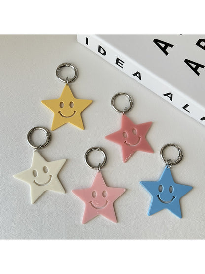 Stylish five pointed star keychain hanging from a black leather bag zipper
