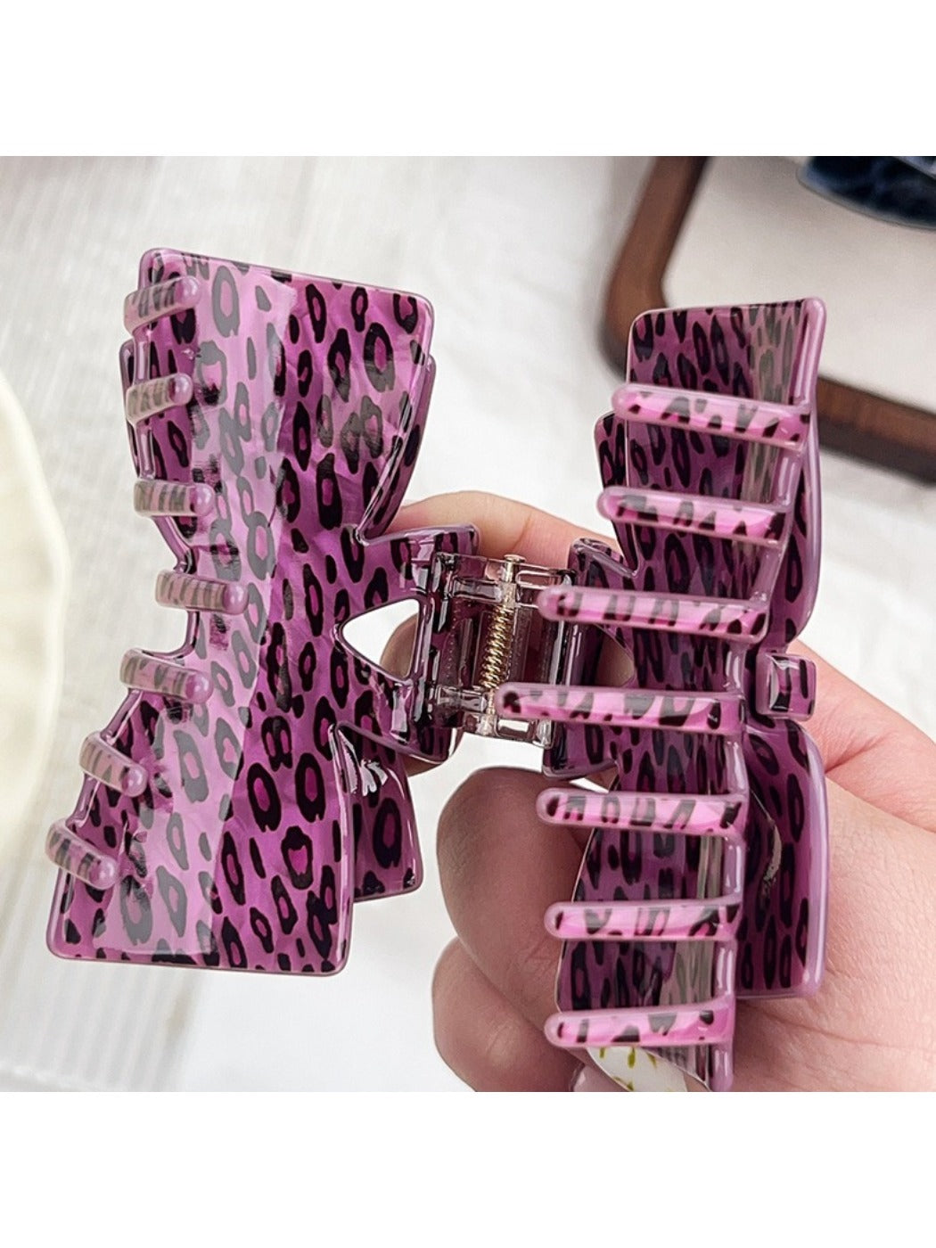 Beau leopard print claw clip holding hair in a half-up hairstyle