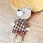 Fabric patchwork bear keychain hanging from a keyring with visible stitching and colors