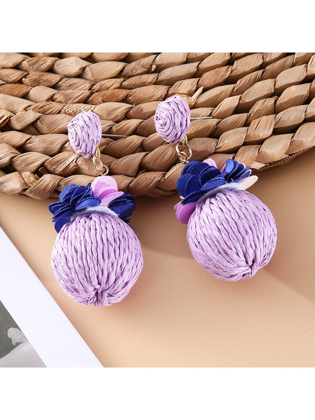 Earedge raffia ball earrings shown from above highlighting texture and color