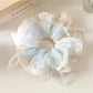 Close-up of Gifty scrunchie with a cute bow embellishment in soft pink fabric