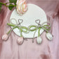 Side view of the bow and tulip pendant keychain with metal ring