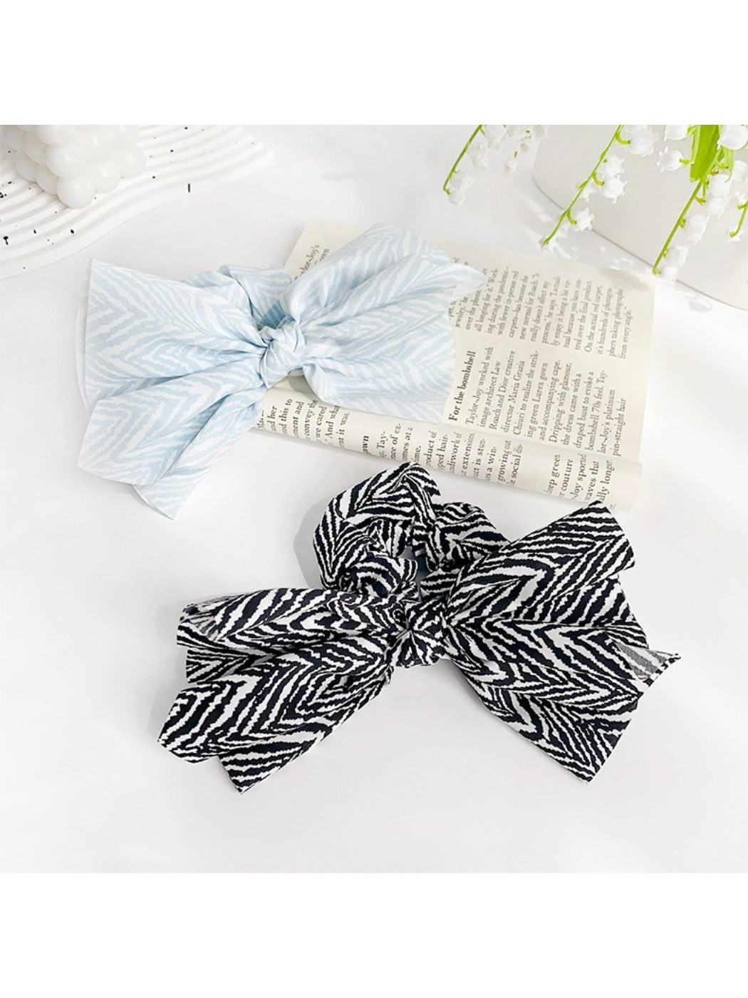 Model wearing striped bow scrunchie holding hair in a ponytail