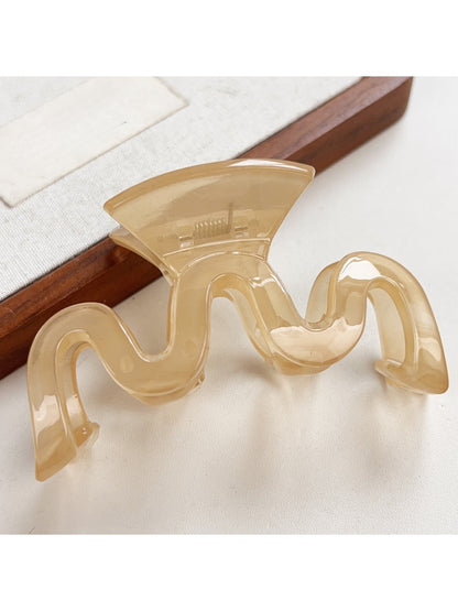Beau wave-shaped hair claw clip holding thick hair in a bun