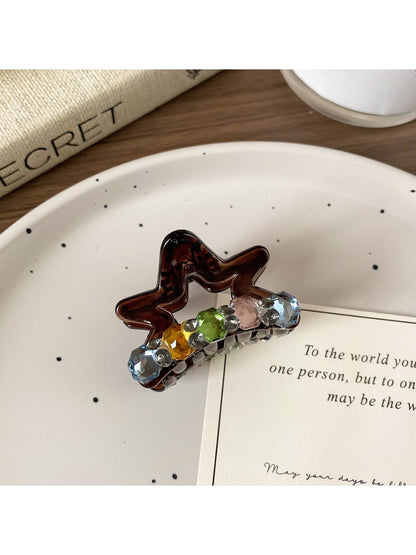 Beau delicate star claw clip worn in hair, securing a ponytail
