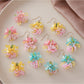 Close-up of small colorful beaded flower cluster earrings on white background