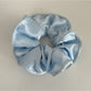 Gifty satin scrunchie in soft pink placed next to matching hair accessories