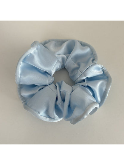 Gifty satin scrunchie in soft pink placed next to matching hair accessories